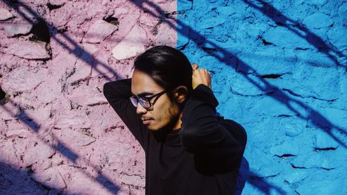 Young man standing against wall