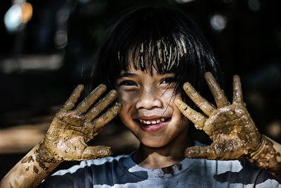 Close-up portrait of girl covered in mud