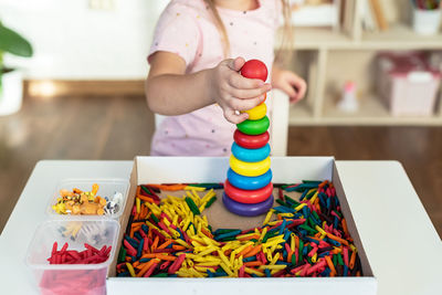 Cropped hand of woman holding toy blocks on table