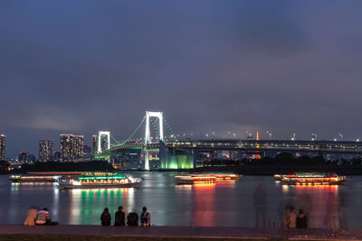 Bridge over river in city at night