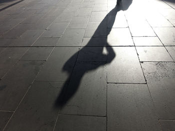 Shadow of people walking on sidewalk