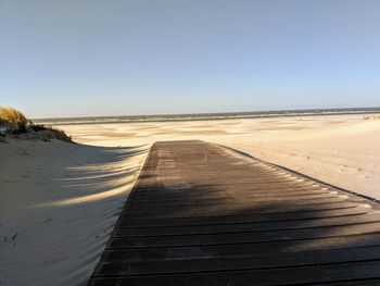 Scenic view of beach against clear blue sky