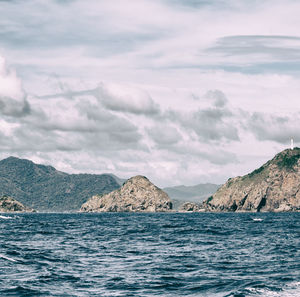 Scenic view of sea and mountains against sky