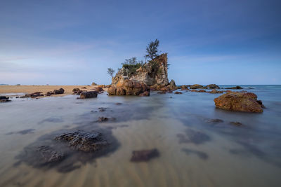 Rocks in sea against sky