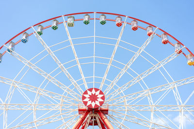 Low angle view of ferris wheel against clear blue sky