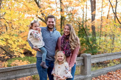 Portrait of smiling family standing against trees