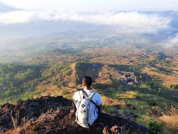 Young man looking at the view from the top of the mountain