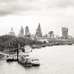 Boats in river with city in background