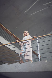 Low angle view of young woman standing on steps