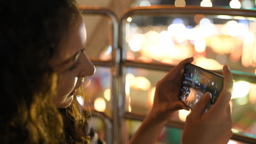 Portrait of woman photographing through smart phone