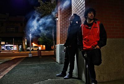 Men standing on street at night