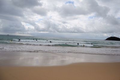 Scenic view of beach against cloudy sky