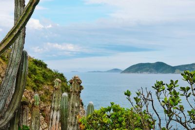 Scenic view of sea and mountains against sky