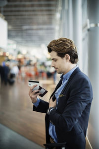 Businessman holding passport and credit card at airport