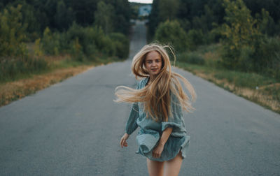 Portrait of smiling young woman on road