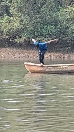 Full length of man jumping by lake