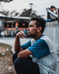 Man eating while sitting in city