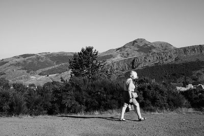 Rear view of woman standing on golf course