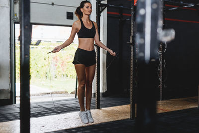 Full length of young woman skipping