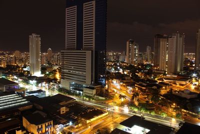 Illuminated cityscape against sky at night
