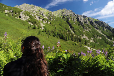 Rear view of woman walking on landscape against sky