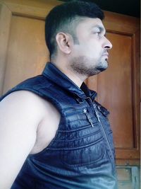 Side view of young man looking away at home