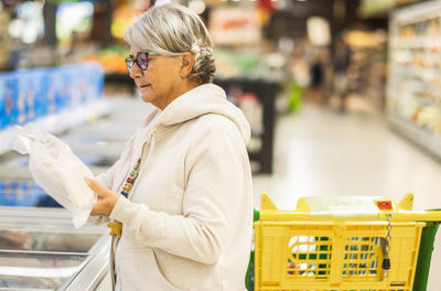 Side view of woman shopping at store