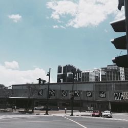 Cars on road in city against sky