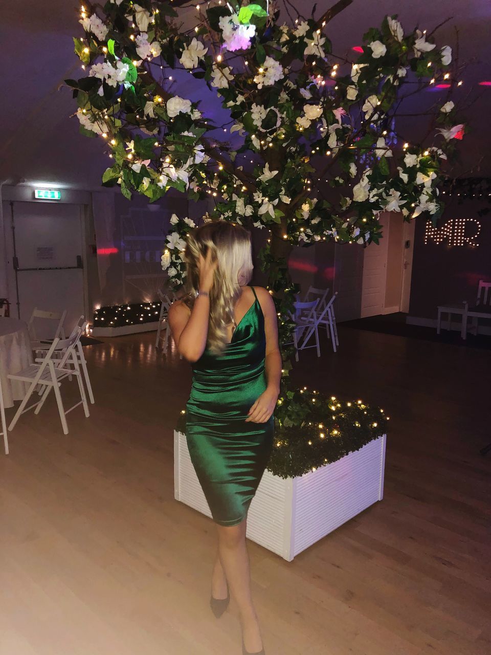 FULL LENGTH REAR VIEW OF WOMAN STANDING BY ILLUMINATED CHRISTMAS TREE