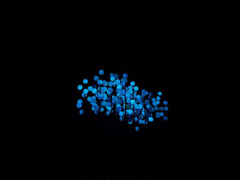 Close-up of illuminated lighting equipment against black background