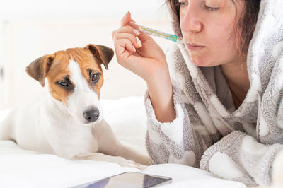 Woman lying down with dog on bed