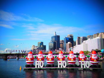 Boats moored in city against blue sky