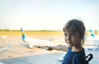 Side view of boy looking away while standing against sky