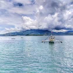 Sailboat sailing on sea against sky