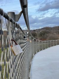 Footbridge over river against sky