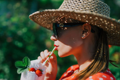 Side view of young woman drinking water