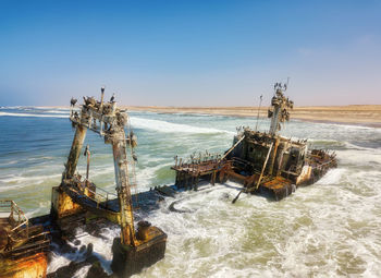 Abandoned ship in sea against sky