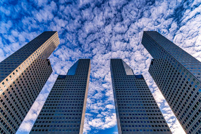 Low angle view of modern buildings against blue sky