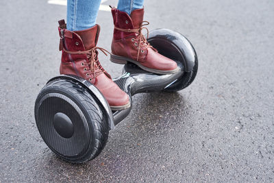 Low section of person standing on hoverboard over road