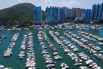 Boats moored in harbor against buildings in city