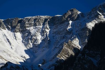 Scenic view of snowcapped mountains against clear blue sky