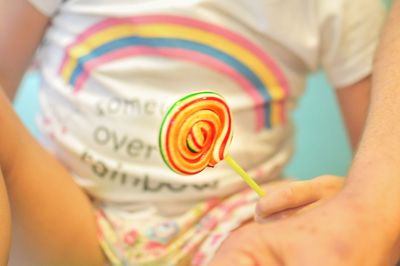 Cropped image of person holding lollipop 