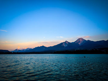 Scenic view of lake against blue sky during sunset