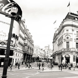 People on street in city against sky