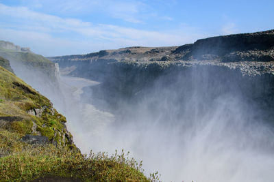 Scenic view of waterfall against sky