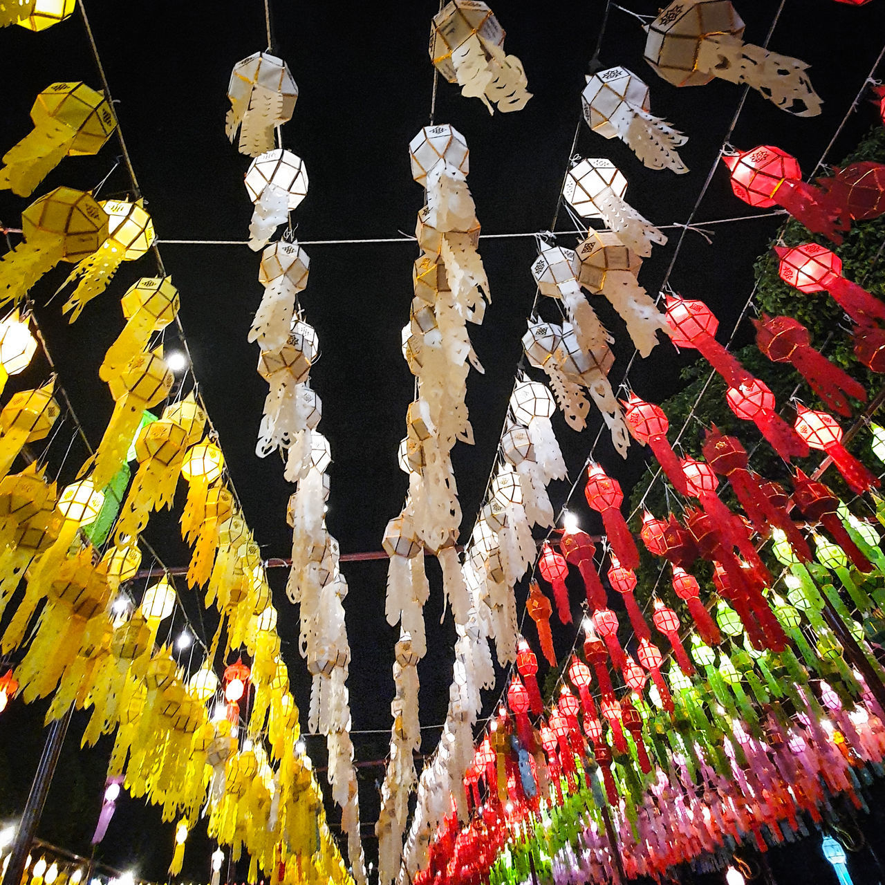 LOW ANGLE VIEW OF DECORATIONS HANGING FROM CEILING AT TEMPLE