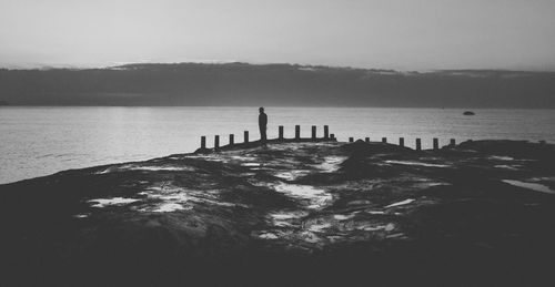 Silhouette people in sea against sky