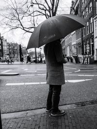 Full length rear view of man walking on road