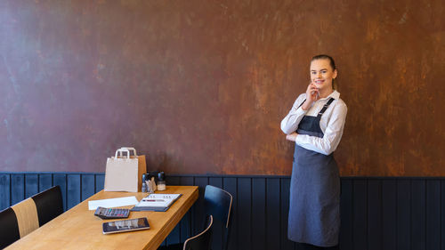 Portrait of woman standing on table at home