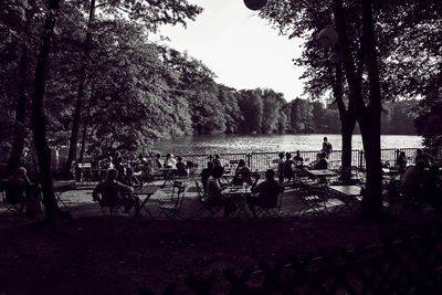 People relaxing in park against sky